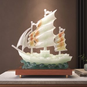 Jade Sailing Ship Statue displaying gold ingots and wooden base on living room console