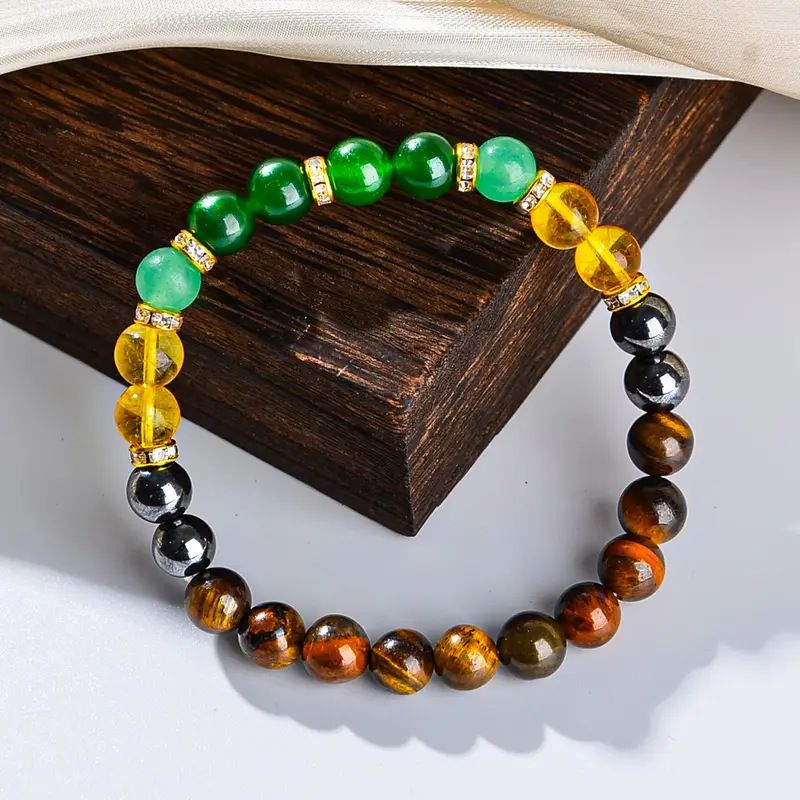 Close up of Wealth Manifestation Bracelet showcasing natural Green Aventurine and Tiger Eye crystal textures on dark wood